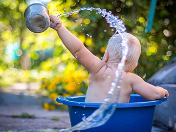 Kleinkind badet im Eimer